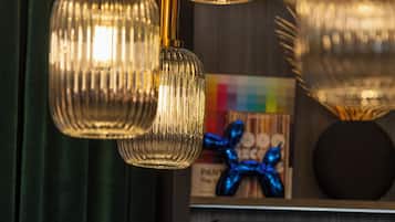 Un lustre doté de plusieurs abat-jours en verre et une photographie encadrée accrochée au mur.