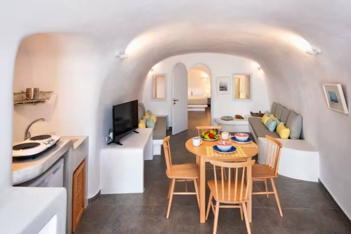 A compact living space with a dining area, kitchenette, and seating area.