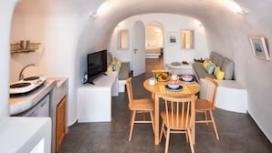 Un espacio habitable compacto con comedor, kitchenette y zona de estar.