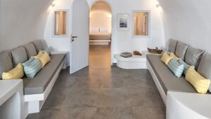 Un interior moderno con dos sofás enfrentados, una mesita y una puerta que da a un dormitorio.