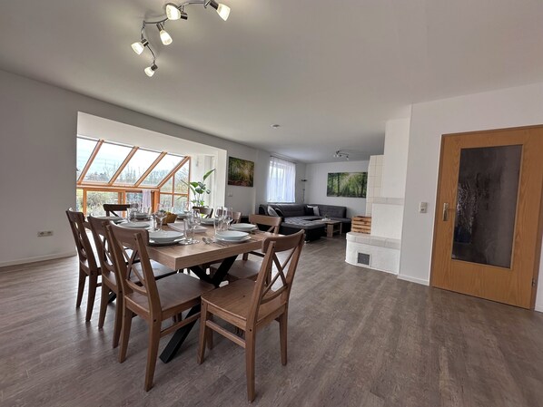 Un espacio moderno tipo sala de estar con comedor, sofá y chimenea.