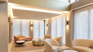 Un salon moderne avec un canapé, des fauteuils et une table basse.