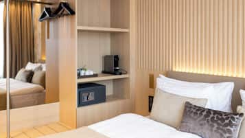 Ein Hotelzimmer mit Bett, Kleiderschrank, Schreibtisch mit Computer und Spiegel.