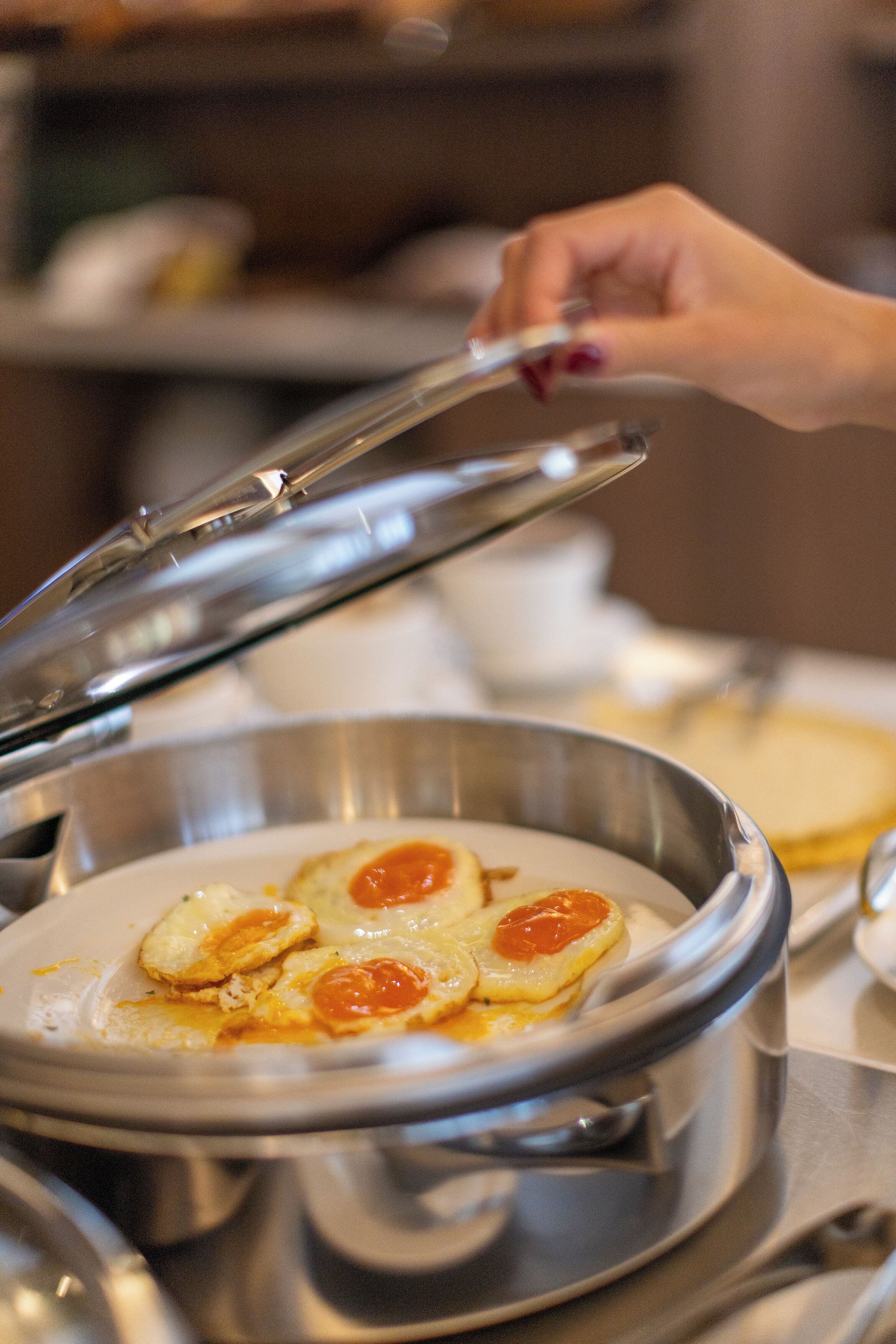 A close-up of a breakfast dish with eggs and a sauce, served in a metal bowl.