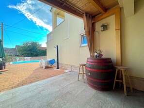 A covered patio area with a pool, outdoor furniture, and a large barrel. - Villa Eternity (Vinodol)