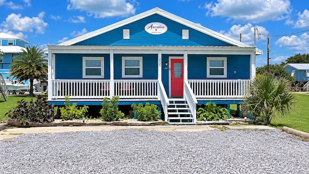 A two-story building with a red door and a blue roof, labeled 'Auralee.'