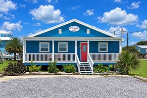 A two-story building with a red door and a blue roof, labeled 'Auralee.' - Auralee Unit 2 - Beach Access - Island Realty (Grand Isle)