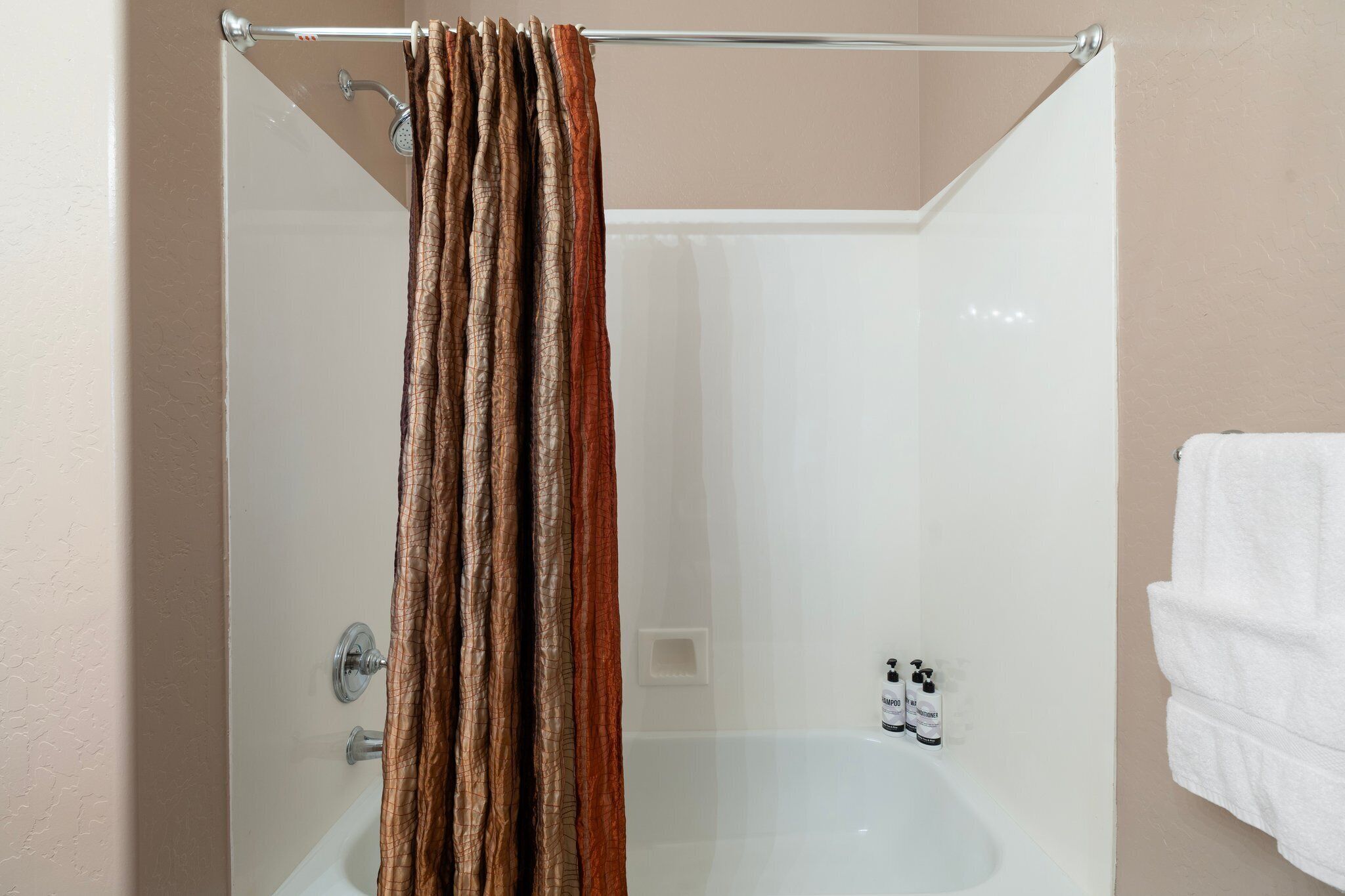 A shower with a curtain, a bathtub, and a towel rack.