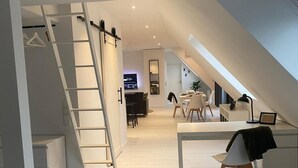 A modern loft-style apartment with a loft bed, a desk area, and a dining space. - Spacious modern DG apartment Schloofschdubb near Kassel 70 sqm (Fuldatal)