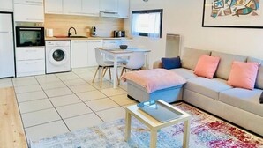A compact living space with a kitchenette, a dining area, and a sofa.