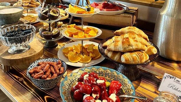 A buffet table with various food items and a potted plant. - Piesteritzer Hof - Hotel Garni (Lutherstadt Wittenberg)
