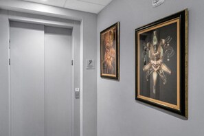 Ein Flur mit einer geschlossenen Tür und zwei gerahmten Kunstwerken an der Wand.