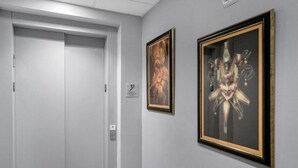 Ein Flur mit einer geschlossenen Tür und zwei gerahmten Kunstwerken an der Wand.