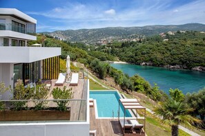 A modern building with a rooftop pool, overlooking a coastal area with a clear view of the sea and hills. - Zavia Villas-Villa Bita, Seafront with Private Pool (Syvota)