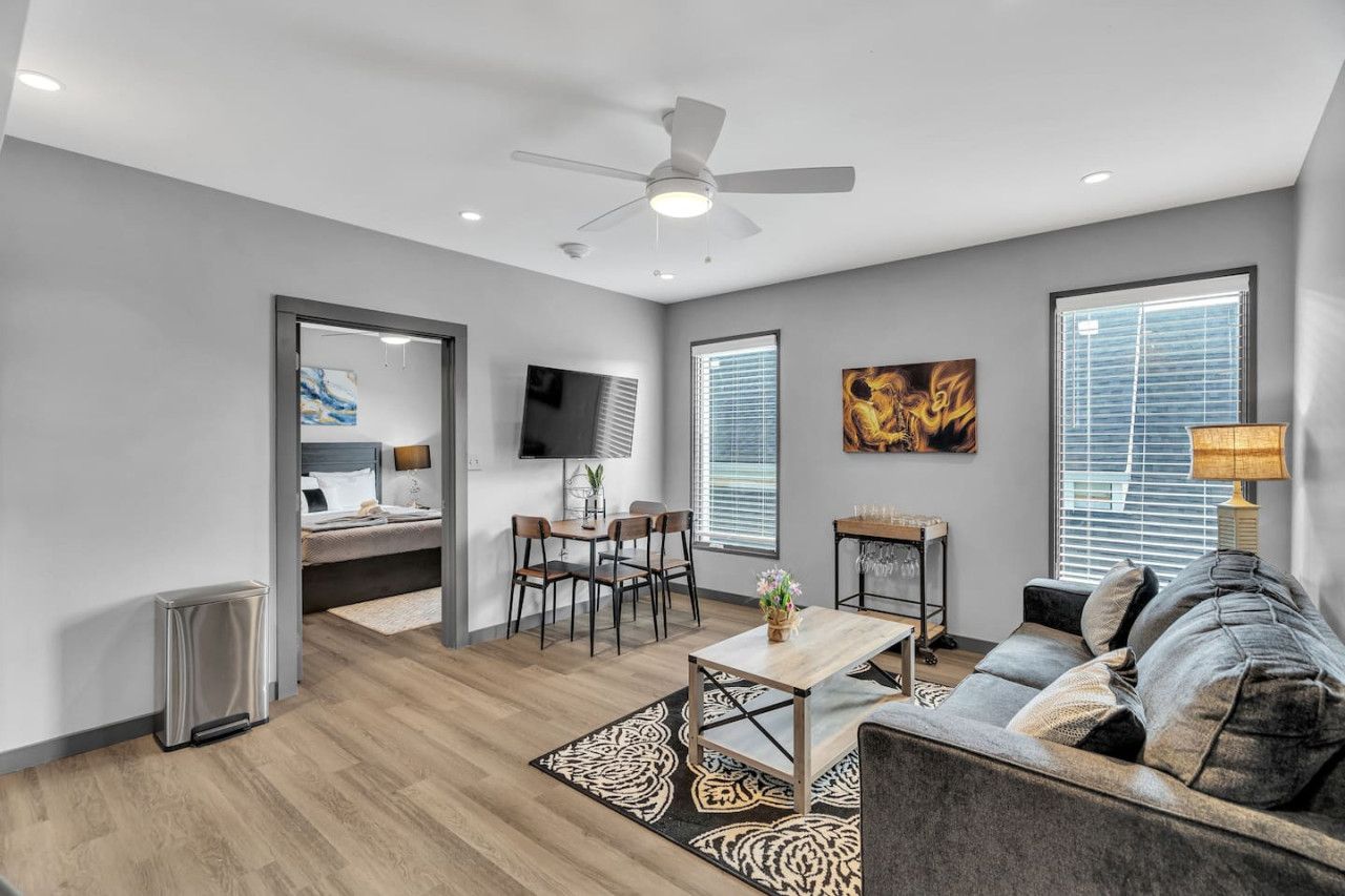 A modern living room with a sofa, coffee table, and dining area.