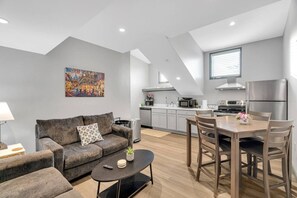 Un appartement moderne comprenant un espace de vie, une cuisine et un coin repas.