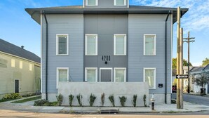 A modern two-story building with a grey facade, numbered 4200, featuring a central entrance and a small overhang above the main door. - Bywater Haven: Near FQ&Frenchman + Secure Parking (New Orleans)