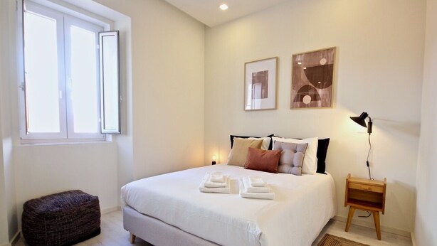 A bedroom with a bed, bedside tables, a window, and artwork on the wall. - Marjoram Apartment, Santos, Lisbon (Lisboa)