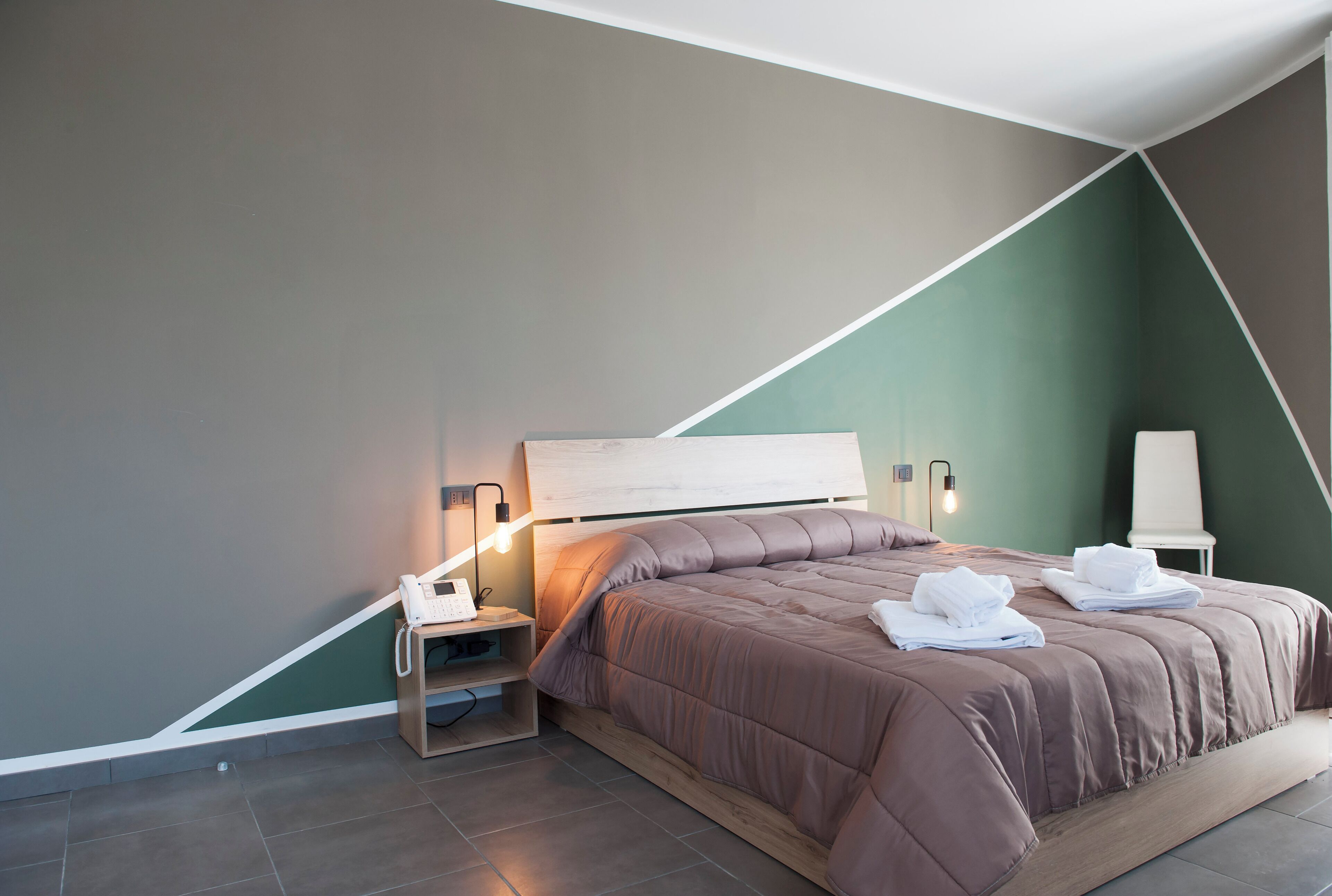 A modern bedroom with a bed, bedside tables, and a nightstand.