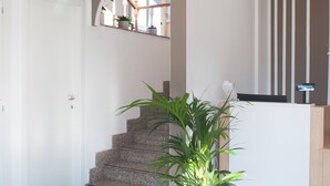 Ein moderner Empfangsbereich mit Treppe, Topfpflanze und Rezeption.