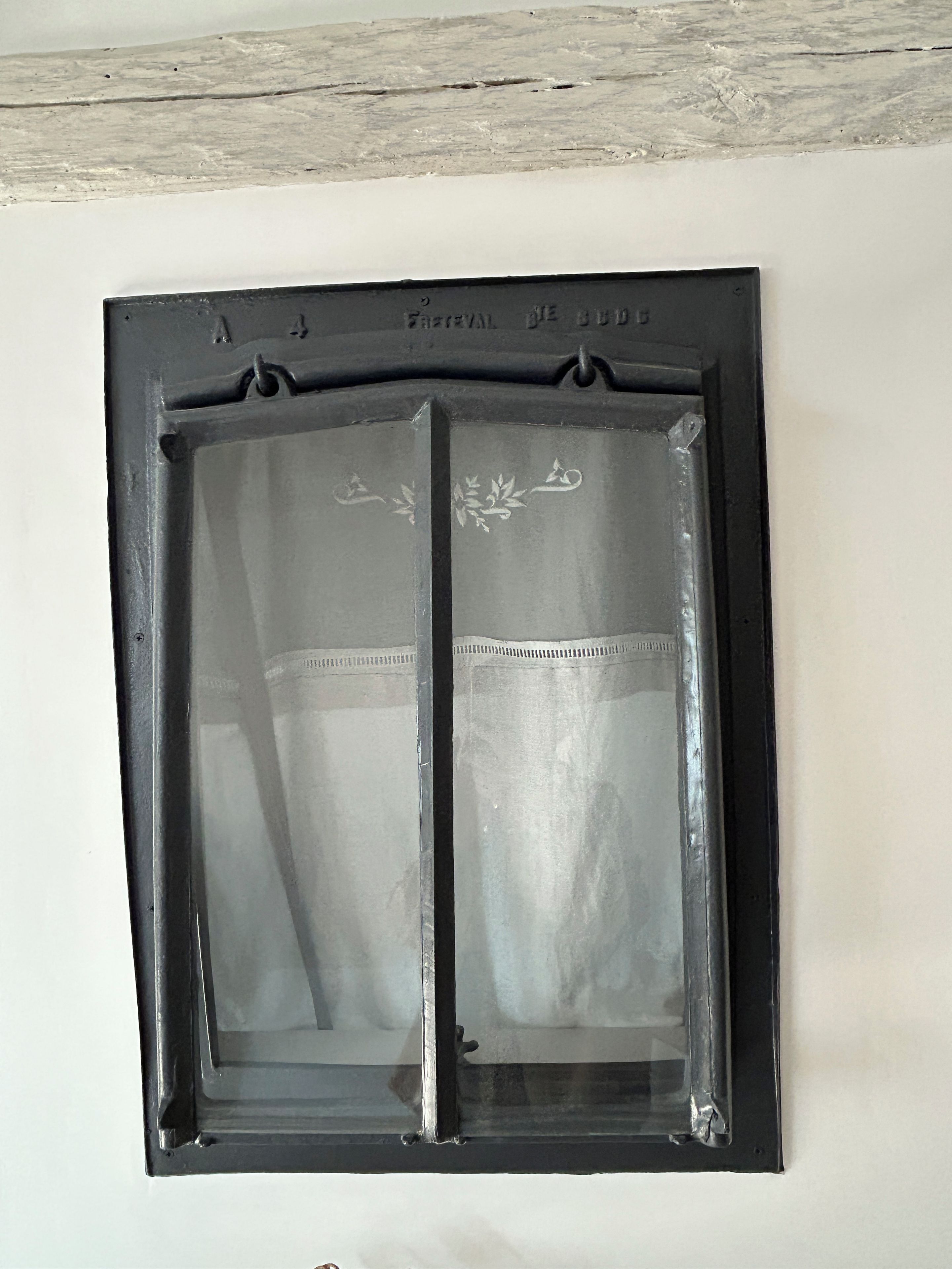 A window with a decorative frame and a clear glass pane.