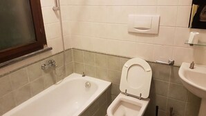 Ein Badezimmer mit Badewanne, Toilette und Waschbecken.