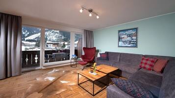 Condo, vista para a montanha | Área de estar | TV de tela plana 55 cm com canais via satélite, livros