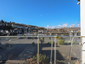 Un puerto deportivo con barcos, cielo despejado y edificios al fondo.