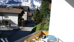A wooden table set for breakfast with a mountain view in the background.