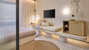 A modern living room with a sofa, a small table, a flat-screen TV, and a decorative wall piece. - Skiathos Senses (Skiathos)