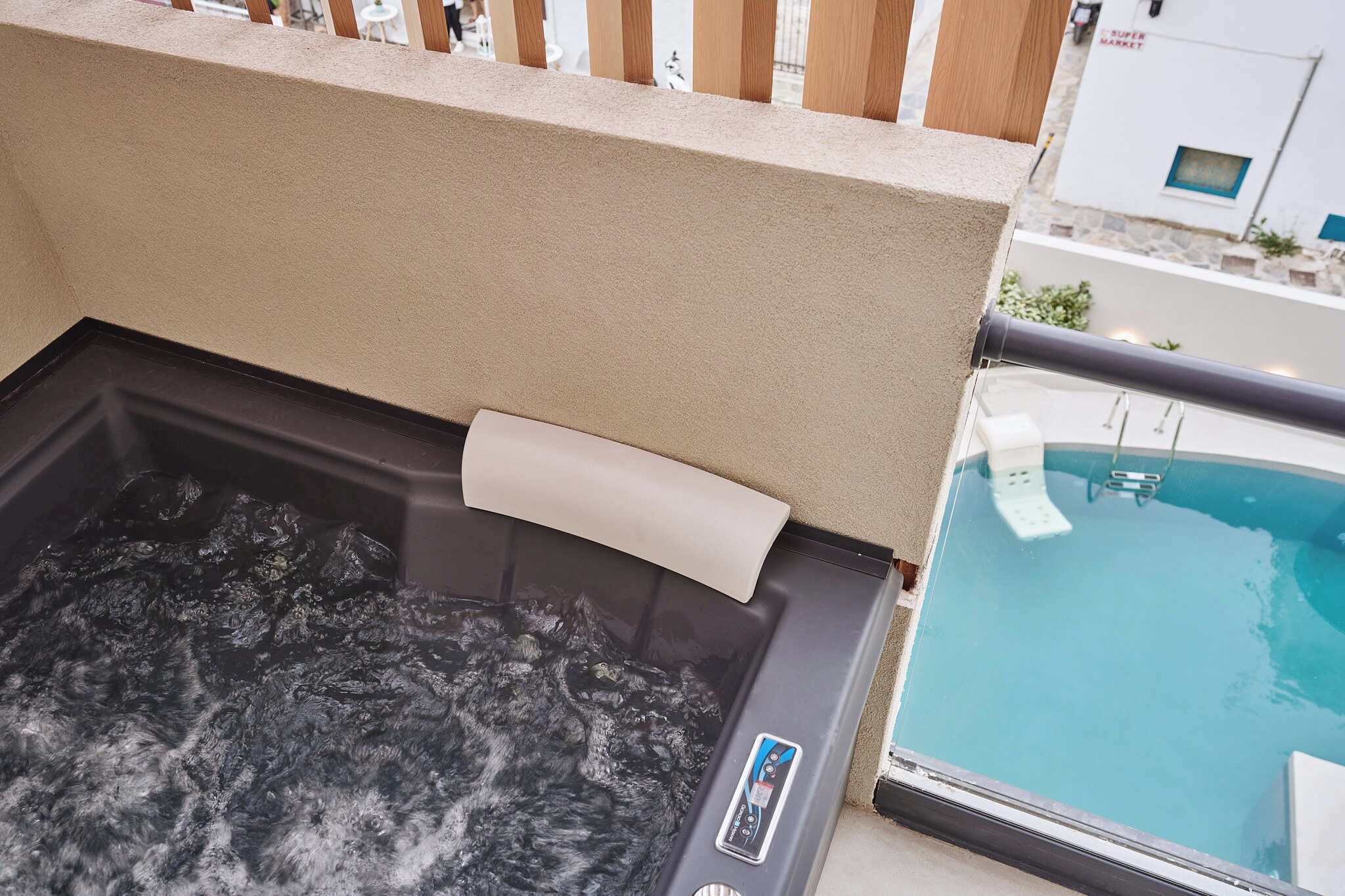 Un jacuzzi et une piscine sur un balcon avec vue sur la rue.