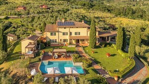 Una villa spaziosa con piscina, diverse camere per gli ospiti e un giardino curato.