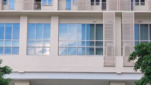 Un edificio de varios pisos con amplias ventanas y un letrero que dice 'Park McKinley West'.