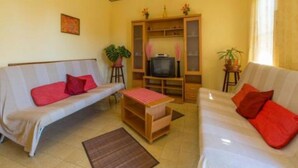 A living room with two sofas, a TV, and a small table.