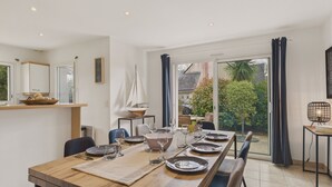A dining area with a wooden table, chairs, and a sailboat model.
