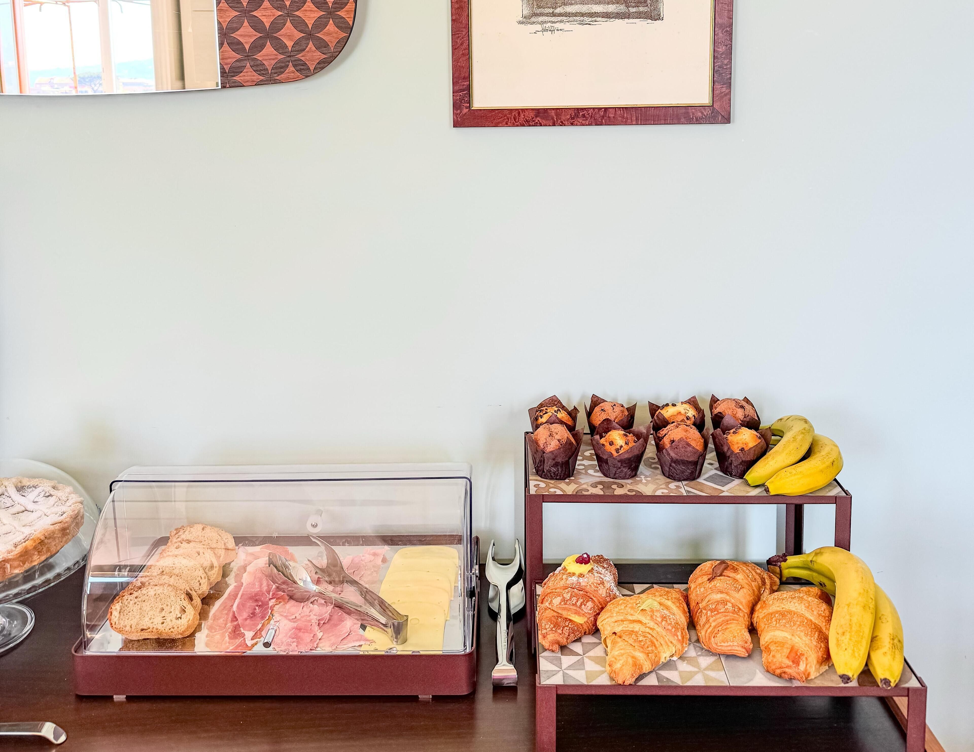 A bakery display with pastries and bread, and a fruit display with bananas.