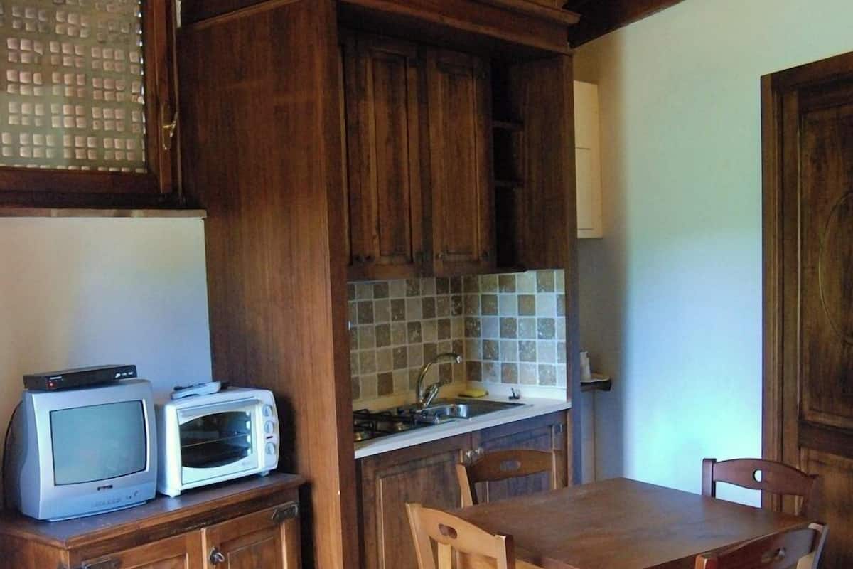 Une cuisine rustique avec des meubles en bois, un pare-feu en carreaux et une table à manger avec des chaises.