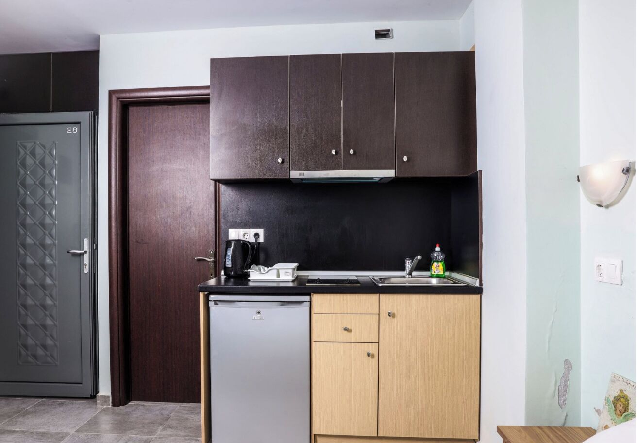 A compact kitchen with a dishwasher, a coffee maker, and a sink.