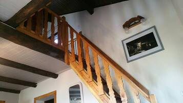 A wooden staircase with a white wall and a framed picture.