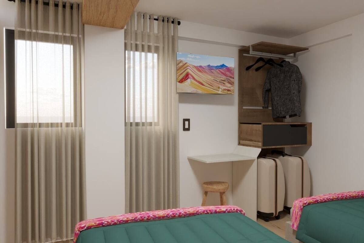 A hotel room with two beds, a desk, a chair, a wardrobe, and a painting on the wall.
