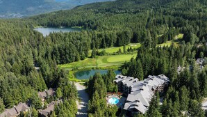 A resort with a pool, golf course, and dense forest.