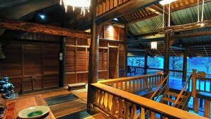 Un interno in legno con una scala che conduce a un balcone affacciato su una distesa d'acqua blu.