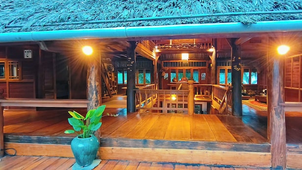 Un edificio in legno con tetto di paglia, pavimenti in legno e una scala centrale.