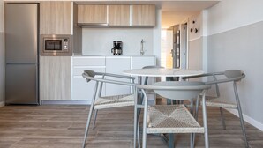 Eine moderne Küche mit integriertem Mikrowellenherd, Kaffeemaschine und einem Edelstahl-Kühlschrank.