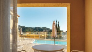 Ein Poolbereich mit Tisch und Stühlen und Blick auf Hügel.