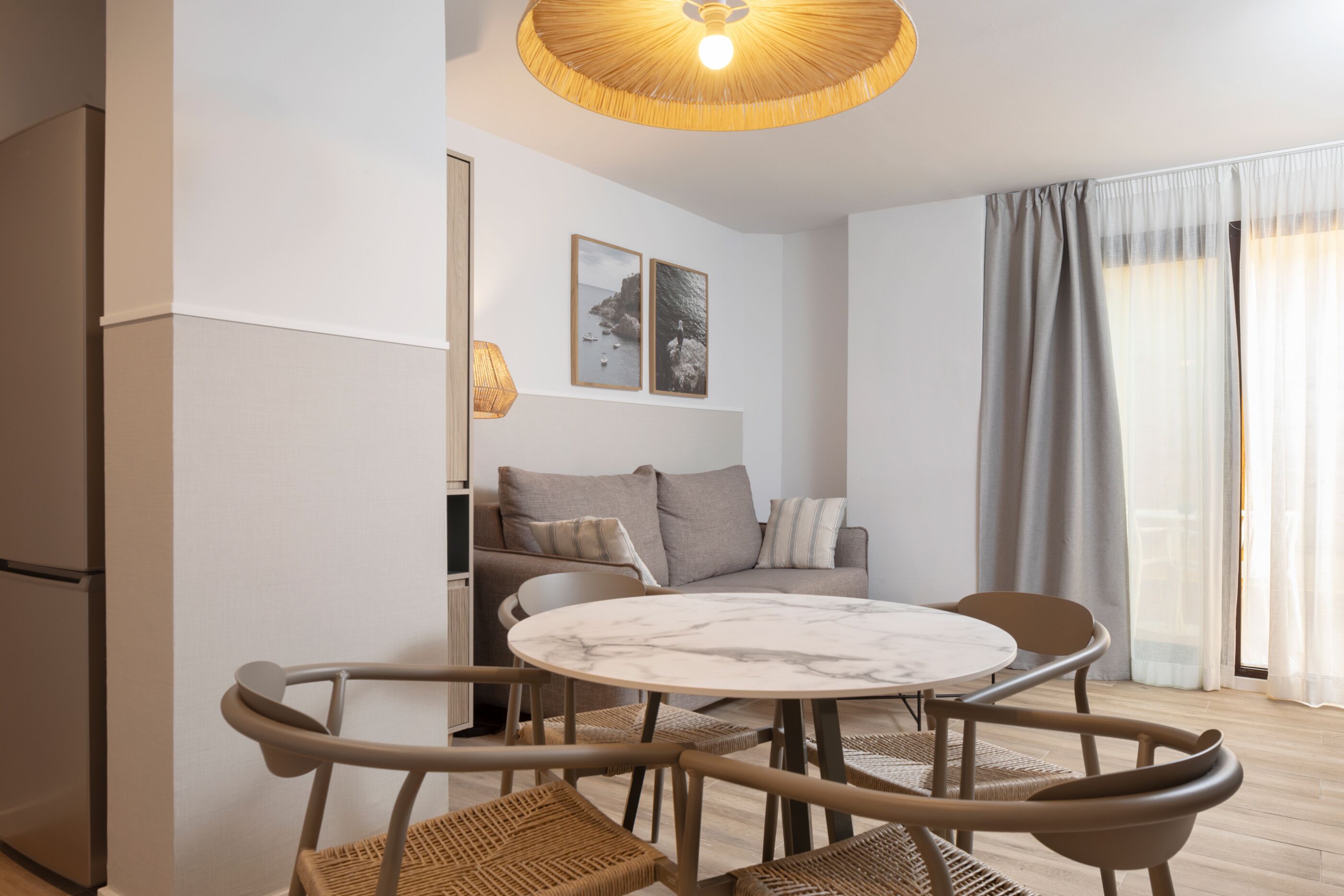 Una sala de estar moderna con una mesa redonda, dos sofás y un comedor.