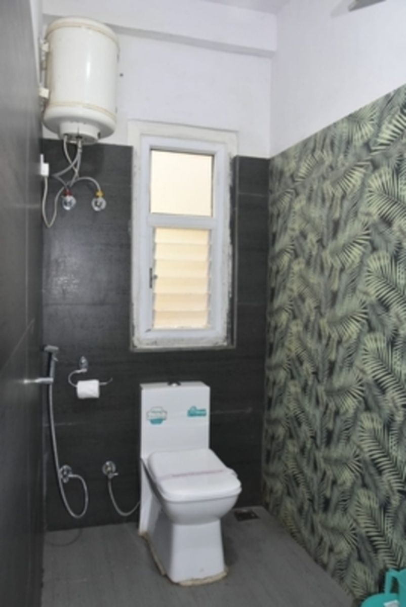 Une salle de bain avec des toilettes, une fenêtre et une douche.