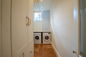 Convenient laundry facilities with two washing machines and a tiled floor.