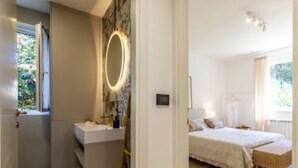 Une chambre à coucher avec un lit, une table de chevet et une fenêtre.