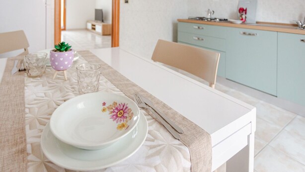 A dining table set with plates, a glass, and a fork. - Pandolfi House - apartment with parking space (Pescara)